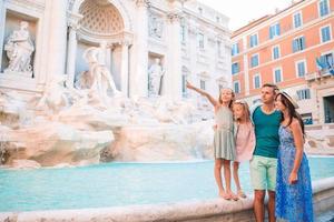 família feliz perto de fontana di trevi com mapa da cidade foto