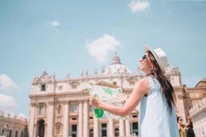 jovem feliz com mapa da cidade na cidade do vaticano e st. Igreja da Basílica de São Pedro, Roma, Itália. foto