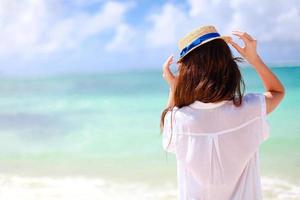 mulher deitada na praia aproveitando as férias de verão olhando para o mar foto