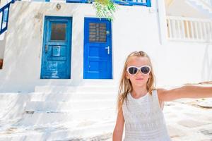 menina adorável tomando auto-retrato nas ruas de mykonos durante as férias de verão grego foto