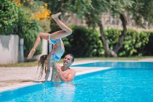 família feliz se divertindo juntos na piscina ao ar livre foto