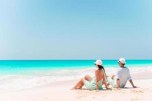 jovem casal andando na praia tropical com areia branca e água do mar turquesa foto