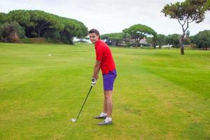 jovem jogando golfe foto