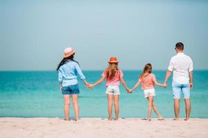 família linda feliz em umas férias de praia tropical foto