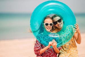 garotinhas engraçadas felizes se divertem muito na praia tropical brincando juntas. foto