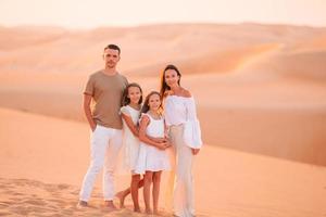 pessoas entre dunas no deserto nos Emirados Árabes Unidos foto