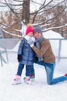 família feliz na pista de patinação ao ar livre foto