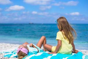 adoráveis meninas se divertem na praia branca durante as férias foto