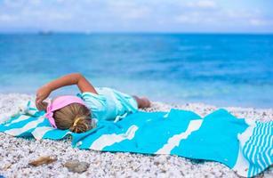 adorável menina se divertindo durante as férias na praia foto