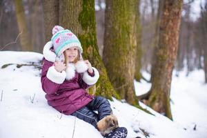 retrato de menina feliz na neve ensolarado dia de inverno foto