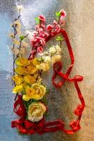 figura 8 feita de fita e flores artificiais para celebração do dia internacional da mulher em fundo prateado com espaço para texto foto