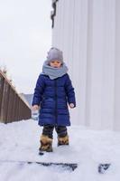 retrato de menina feliz na neve ensolarado dia de inverno foto