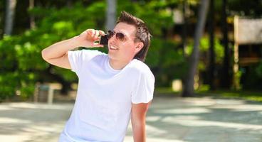 jovem falando ao telefone durante as férias na praia tropical foto