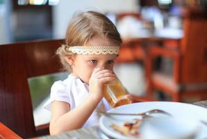 adorável menina tomando café da manhã no restaurante foto