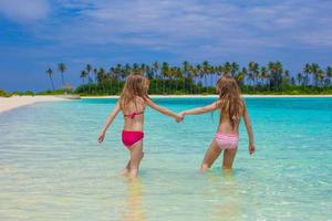 adoráveis meninas felizes se divertem em águas rasas nas férias na praia foto