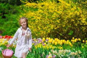 jardim da primavera, flores da primavera, garotinha adorável e tulipas foto