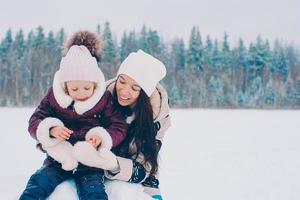 família feliz de mãe e filho aproveita o dia de neve do inverno foto