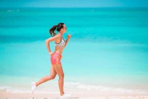 ajuste a jovem mulher na praia tropical em roupas esportivas foto