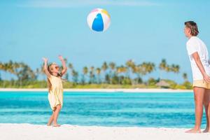 família feliz na praia com bola foto