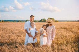 família feliz jogando em um campo de trigo foto