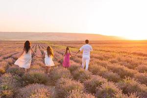 família de quatro pessoas no campo de flores de lavanda foto