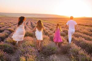 família de quatro pessoas no campo de flores de lavanda foto