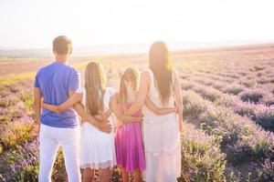 família no campo de flores de lavanda ao pôr do sol foto