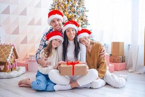 família jovem feliz com crianças segurando presentes de natal foto