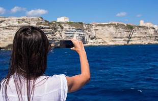 menina tirando fotos em um telefone em bonifacio, córsega, frança