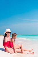 mãe e filha aproveitando o tempo na praia tropical foto