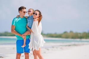 jovem família na praia branca durante as férias de verão foto