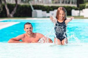 família de mãe e filha aproveitando as férias de verão na piscina de luxo foto