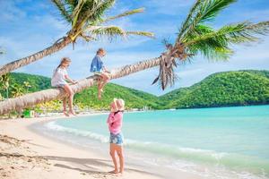 família linda feliz em umas férias de praia tropical foto