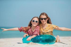 garotinhas felizes e engraçadas se divertem muito na praia tropical brincando juntas foto