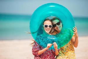garotinhas felizes e engraçadas se divertem muito na praia tropical brincando juntas