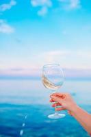 copo de vinho branco na praia tropical foto