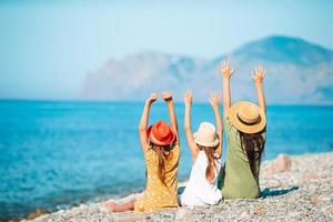 adoráveis meninas e jovem mãe na praia tropical branca foto