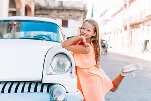 garota turista em área popular em havana, cuba. criança viajante sorrindo foto