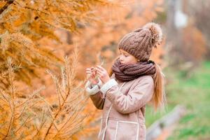 menina com queda no dia de outono foto