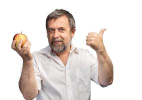 homem de meia-idade sorridente segurando uma maçã vermelha foto