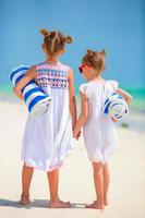 adoráveis meninas com toalhas na praia tropical foto