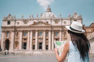 jovem feliz com mapa da cidade na cidade do vaticano e st. igreja basílica de pedro foto