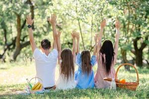 família feliz em um piquenique no parque em um dia ensolarado foto