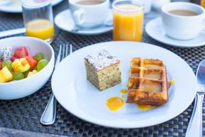 deliciosos waffles, bolo, café e suco servidos no café da manhã no restaurante do resort foto