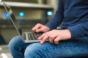 empresário usando laptop ou notebook enquanto está sentado na cadeira no aeroporto foto