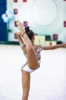 pequena ginasta treinando no tapete e pronta para competições foto