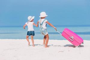 menina adorável com grande bagagem durante as férias de verão foto