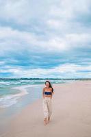 jovem moda mulher de vestido verde na praia foto