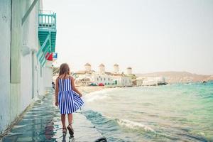 menina adorável na pequena veneza a área turística mais popular da ilha de mykonos, grécia. foto