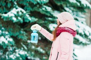 Dia de inverno. mulher segurando a lanterna de natal ao ar livre no lindo dia de neve de inverno foto